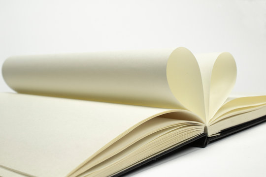 Two blank diary pages that becomes one heart shape. Clean photo of notebook on white background, as concept for valentines day, love stories etc.