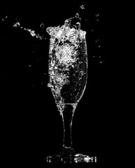 Splashes and drops of water in a glass are isolated on a black .