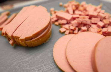 Sliced sausage on a plastic board.