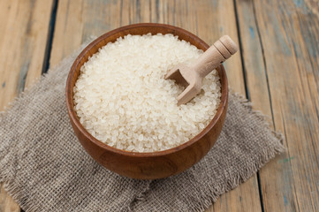 Rice bowl and spoon are placed on old wooden floor.