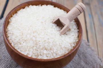 Rice bowl and spoon are placed on old wooden floor.