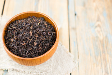 close-up of dry chinese tea in woonden bowl