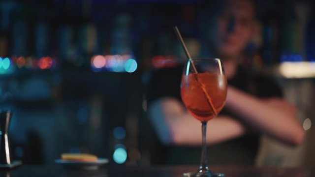 bartender mixing aperol spritz cocktail in night club