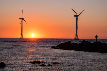 Beach sunset and wind power plant