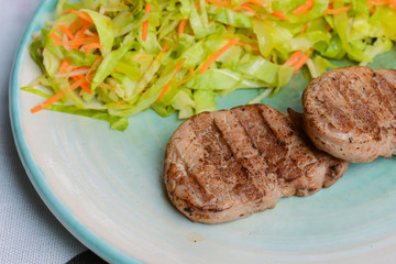 Grilled juicy steak with vegetable salad and herbs. Concept for a tasty and healthy meal.