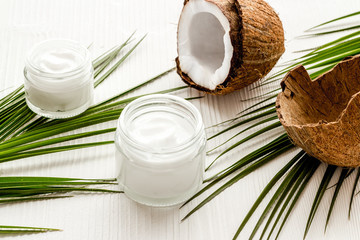 Face care. Coconut cream in glass jar on white background