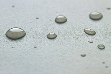 Fototapeta na wymiar Drops of water on a white rough