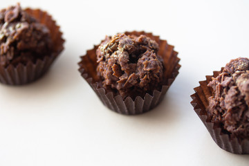 Chocolate corn flake cake in brown paper cupcake case. Close up of sweet dessert with gold dust sprinkles. Simple party cake recipe for children