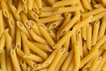 Food background -  dry penne pasta, whole wheat uncooked ingredient