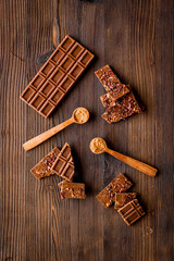 Homemade chocolate. Bars and broken pieces on wooden table