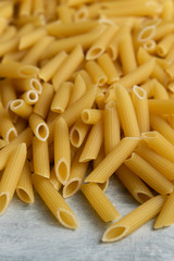 Food background -  dry penne pasta, whole wheat uncooked ingredient