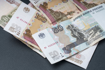 Russian hundred-ruble bills on a dark background, the concept of the Russian economy's recession, selective focus