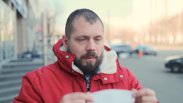 Shocked bearded hipster man putting on a protective mask. The guy in fear puts on a respirator. Health and safety life, N1H1 coronavirus, virus protection concept 4k