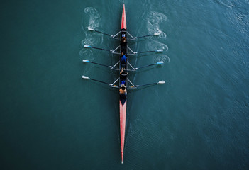 Kayak from above with 4 rowing people. Blue and aqua water background. Sport and moving concept. Red kayak and 8 paddles. - obrazy, fototapety, plakaty