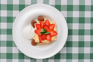 Cake of puff pastry with strawberry. Tasty delicious sweet Italian dessert with strawberry, cream served in white plate