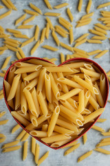 Food background -  dry penne pasta, whole wheat uncooked ingredient
