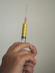 woman hand is holding the syringe with a sharp needle