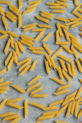 Food background -  dry penne pasta, whole wheat uncooked ingredient