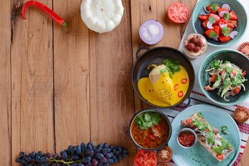 Paprika stuffed pepper with the minced meat and pumpkin sauce served in a pan over rustic wooden table.