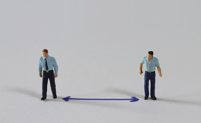 Fototapeta premium The concept of social distancing. Miniature people standing at a distance from each other.
