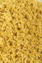 Food background - dry farfalle pasta, whole wheat uncooked ingredient
