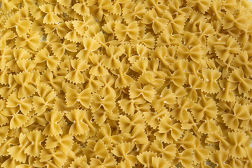 Food background - dry farfalle pasta, whole wheat uncooked ingredient