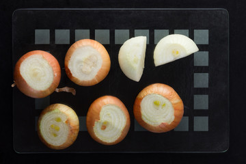 Top view of whole unpeeled onion on the black background