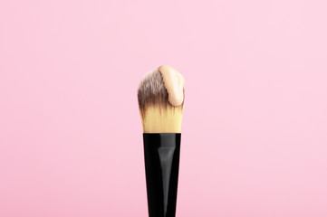 Makeup brush with drop of face foundation. Daily facial treatment. Equipment for cosmetology...