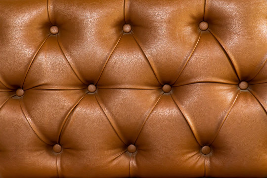 Brown leather upholstery chair with buttons pattern background. Dark brown vintage sofa elegant leather with buttons texture surface