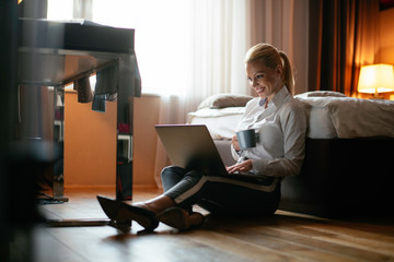 Young beautiful woman enjoying in coffee.Businesswoman working from a hotel room.	