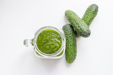 green detox smoothie cocktail in a glass jar and fresh cucumbers