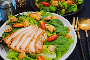 Couple bowl of healthy green vegetable salad on top with tomatos and biscuits. Side dish with salt pepper bottle, white cream and thousand island salad dressing