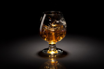 Ice cube fall and splash in beautiful glass goblet