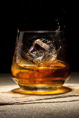 Close-up ice cubes falling into a glass