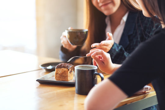 Closeup image of women enjoyed eating  dessert and drinking coffee together in cafe