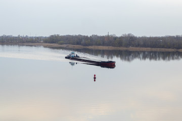 cargo ship sailing along the Dnieper river in Ukraine in spring afternoon