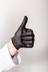 Fingers symbol good. Isolated on white. Healthy medicine concept. Sign made of black medical gloves.