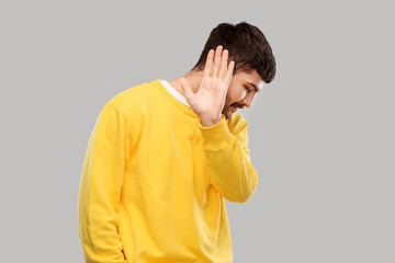 rejection and people concept - serious young man in yellow sweatshirt showing refusal gesture over...