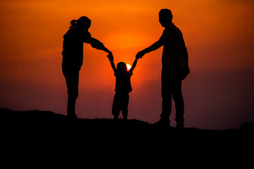 Fototapeta na wymiar Happy family, father, mother, son in nature, sunset