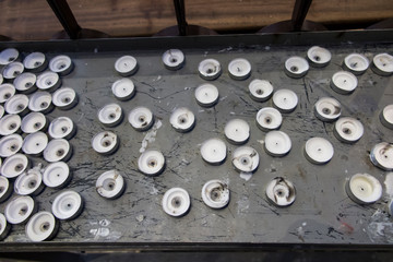 A group of extinguished, burned out votive candles in a church.