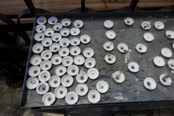A group of extinguished, burned out votive candles in a church.