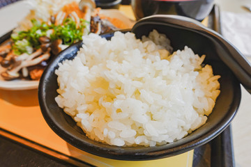 Japan rice in a black bowl with spoon