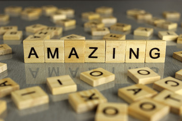 word amazing is made of square wooden letters on a gray background