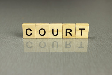 word court made of square wooden letters on a gray background