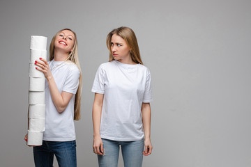 Obraz premium Young caucasian teenagers in white t-shirts, jeans have a lot of toilet paper and quarrel