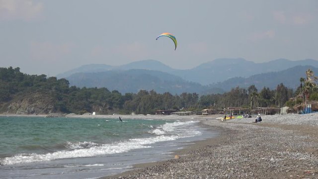 Fethiye, Turkey - 27th of Martch 2020: 4K Viewing kitesurfers riding and rolling in the wind on the beach
