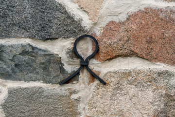 Old rock wall with an iron loop as reinforcement