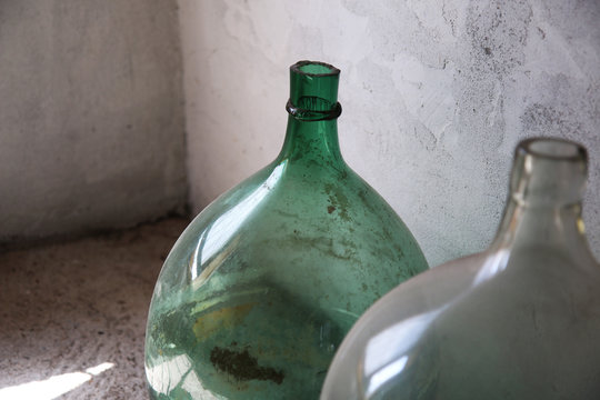 Primo piano di damigiane in vetro, contenitori per vino o aceto; oggetti vintage d’epoca