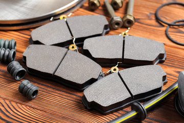 brake parts on wooden background  brake pads, disc, brake hose, guides, cylinders- Image