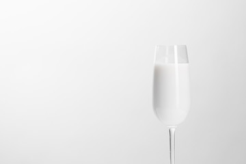 Empty glass with white liquid on a white background. Milk in a glass. Minimalism. Isolated